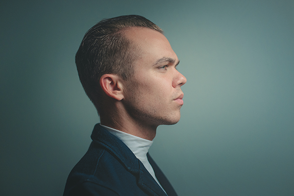 Anti-aging for Men: The Best Anti-aging Skincare for Men, image of a man with a green backdrop looking to the right.