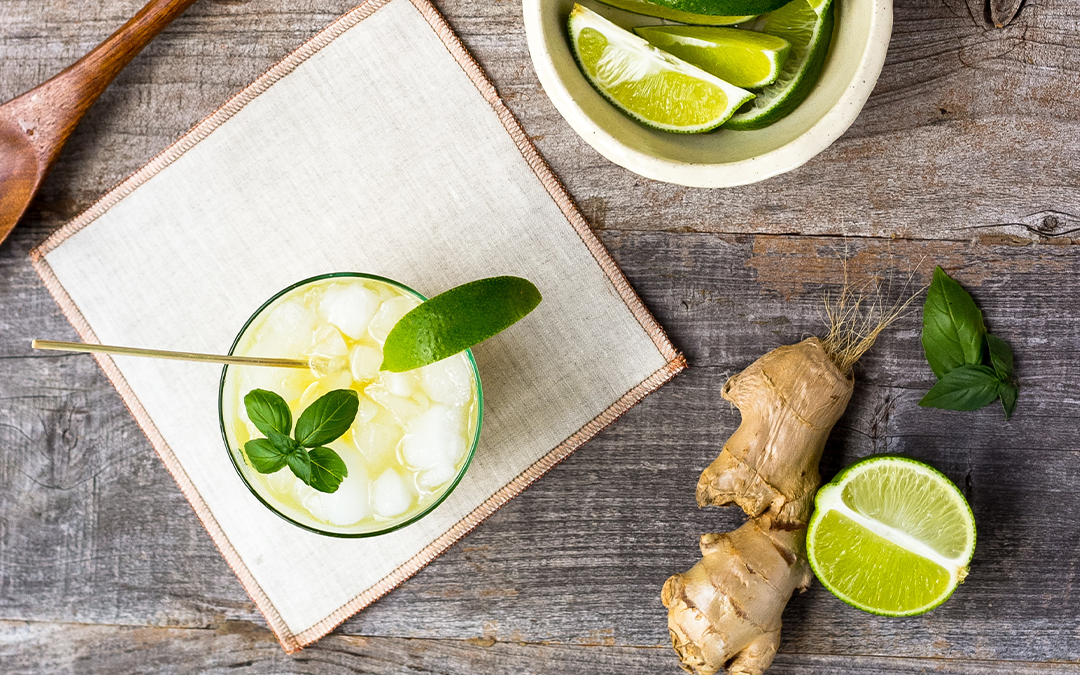 Healthy alcohol for the holiday's, Healthy(Ish) Drinks for Your Winter Party, image of a cocktail with ginger, lime on a wooden table