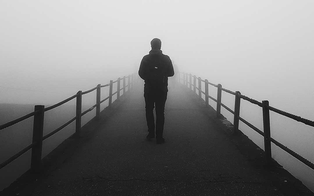Cognitive Performance, Man walking bridge in the fog unsure of where to go, black and white photo
