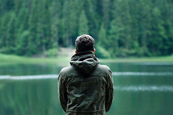 Manhood, image of a man wearing a jacket looking over a lake