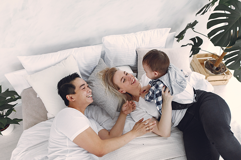 natural Supplements to Increase Sperm Count, image of a family laying on a bed holding their child