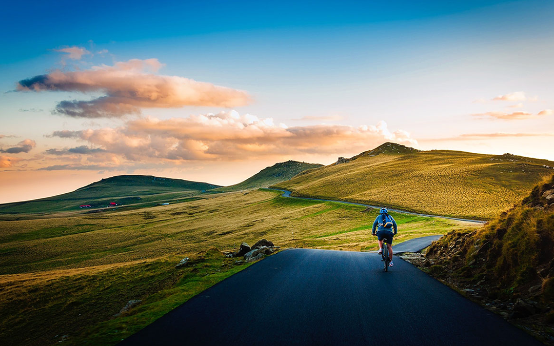 4 Simple Ways to Improve Heart Health, image of a man riding a bicycle on a road during the sunset