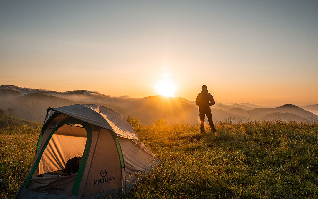 The Power of Moments, image of a man camping during a sunset